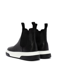 Un par de botas de tobillo negras de cuero, tipo slip-on, con paneles laterales elásticos, lengüetas para tirar y suelas de goma gruesas en blanco y negro, vista trasera en ángulo.
