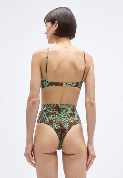 Barna bikini zöld absztrakt szövegnyomattal. Állítható vékony pántok, hátul kapcsos záródás, magas derekú alsórész. Simogató, rugalmas anyag.