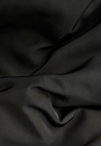 Czarna tkanina o gładkiej fakturze, z delikatnymi poziomymi wzorami prążkowymi. Materiał wydaje się lekki i elastyczny.
