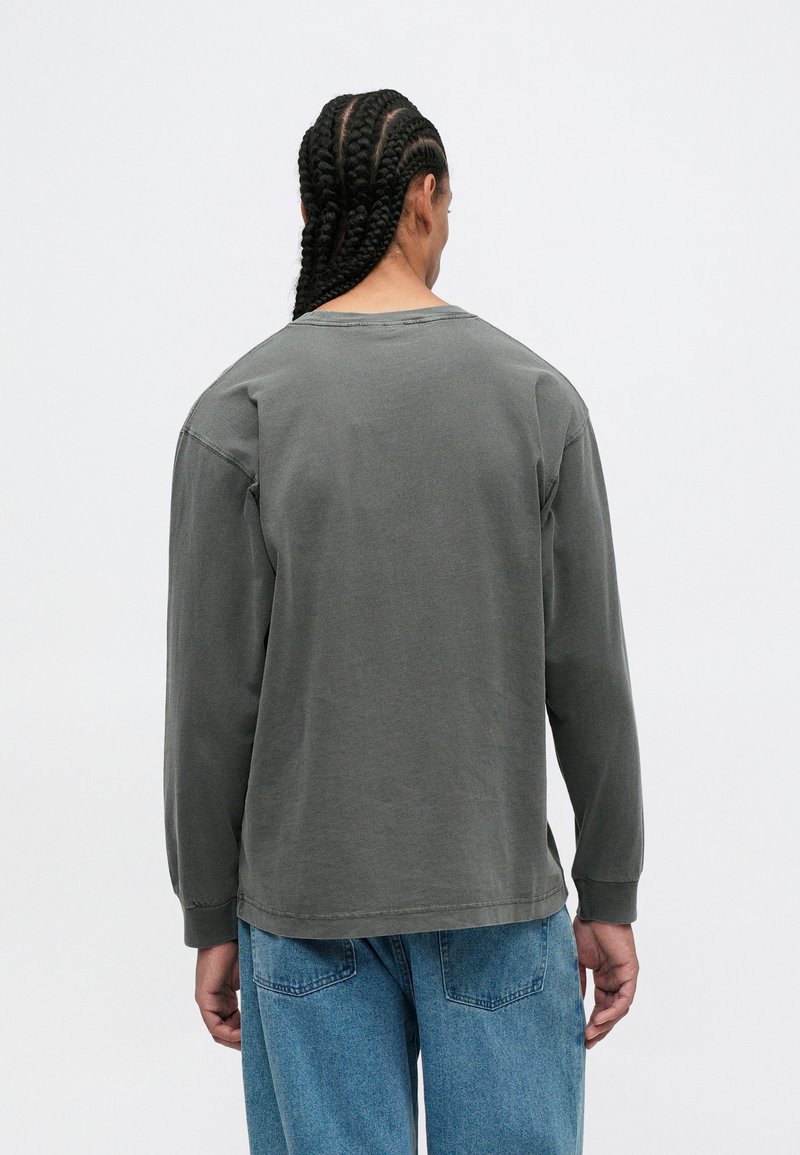 Lange mouwen shirt van donkergroene katoen, heeft een relaxte pasvorm, verlaagde schouders en zichtbare naaddetails op een textuurstof.
