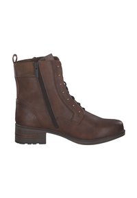 Bottine en cuir marron avec un bout légèrement arrondi, fermeture éclair sur le côté, avant à lacets et des clous en métal sur le côté extérieur. Design à talon bloc.