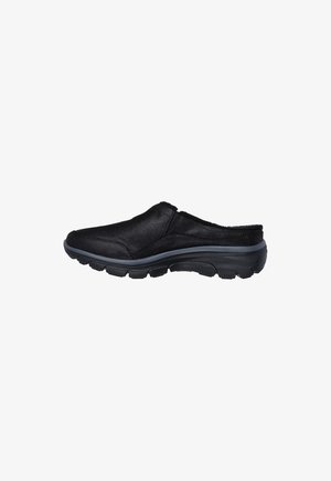 Black slip-on shoe with cushioned sole and textured tread, designed for comfort and easy wear.
