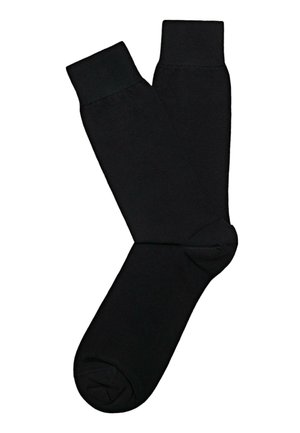 Ein Paar schlichte schwarze Crew-Socken liegen flach auf weißem Hintergrund, überlappen sich an den Knöcheln, Zehen und Bündchen sind sichtbar.