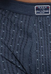 Boxer shorts blu in maglia con un motivo testurizzato, dotati di una vita blu scuro e un'etichetta cucita sul lato anteriore.