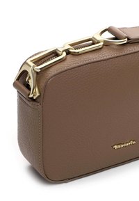 Braune strukturiert Lederhandtasche mit goldfarbener Kettendetails, rechteckiger Form und Reißverschluss mit einem eingravierten Markenlogo an der Seite.