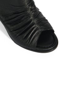 Zwarte leren open teen bootie met geplooid textuur, voorzien van een gladde binnenzijde en een ronde zool. Eenvoudig ontwerp zonder zichtbare hardware.