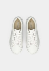 Sneaker bianche in pelle vegana con una finitura liscia, punta tonda, design con lacci e branding sottile sulla soletta. Suola piatta in gomma.