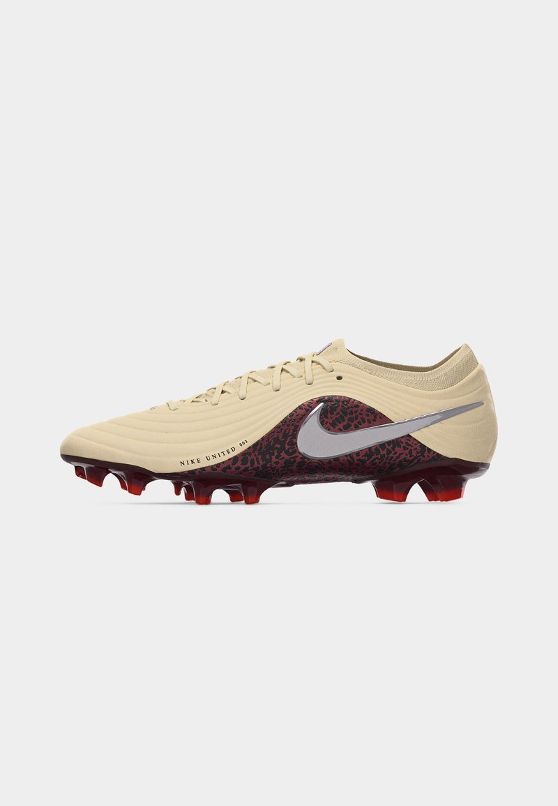 Beige Nike fodboldstøvle med vinrød dyreprint, sølv Swoosh-logo og rødt farvede knopper på en hvid baggrund.