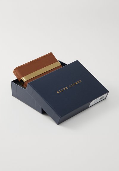 Brown leather wallet with gold band, partially visible in a navy blue box labeled "RALPH LAUREN." Smooth texture and clean lines.