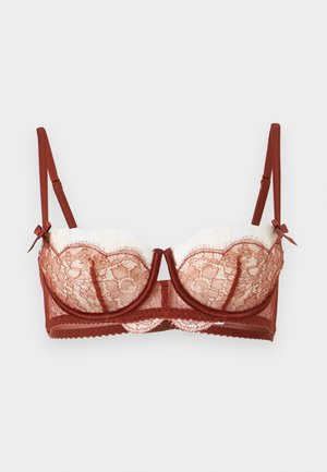 Balconette podprsenka v hrdzavej farbe s kosticami, nastaviteľnými ramienkami, mašličkovými detailmi a priesvitným kvetinovým vzorom na bielych látkových košíčkoch.