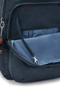 Zaino navy con una texture liscia, dotato di una tasca con zip e un compartimento azzurro. Include un piccolo portachiavi morbido.