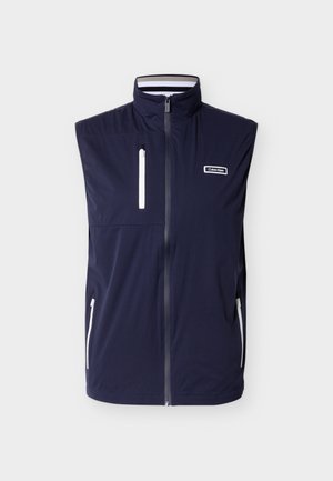 Tumesinine varrukateta vest kõrge kraega, ees lukk, kolm valge detailiga lukuga taskut ja Calvin Kleini logo rinnal.