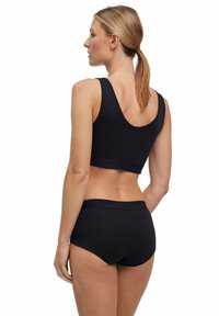 Schwarzes Sport-Bra und Slips-Set, mit glatter Textur, breiten Trägern und elastischem Bund, entworfen für Komfort und Unterstützung.