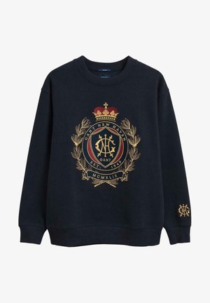 Marineblå sweatshirt med gylden broderet våbenskjold med en krone, laurbærkrans og teksten "GANT NEW HAVEN EST. 1949".