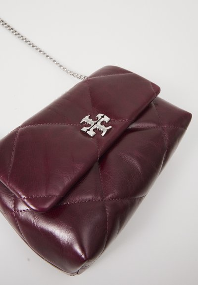 Burgundowa skórzana torebka typu crossbody z pikowanym wzorem, srebrnymi akcentami i wyraźnym logo na zapięciu klapki. Widoczny łańcuchowy pasek.