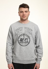 Grauer Pullover mit langen Ärmeln, der "NEW YORK UNIVERSITY" in schwarzer Schrift und einem zentralen Logodesign mit einem emblematischen Siegel zeigt.