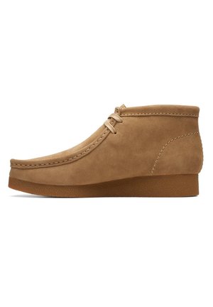 Tan suede ankle shoe with a rounded toe, stitching details along the upper, and a textured rubber sole. Simple lace closure design.