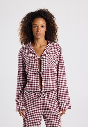 Bordeaux- en witte geruite pyjama's met een cropped ontwerp, open voorkant met strikjes, lange mouwen en een borstzakje.