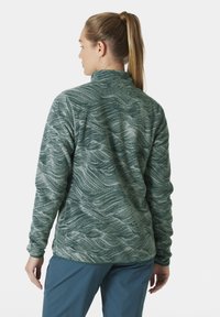 Pull en polaire texturé vert avec un motif en vagues, col montant et manches longues. Idéal pour les activités en plein air.