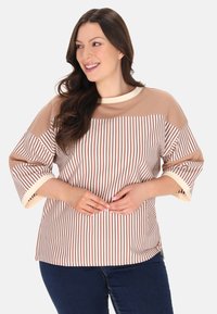 Tricou cu mânecă lungă în dungi maronii și crem, cu decolteu rotund. Material moale, mâneci late și manșete crem contrastante.