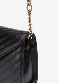 Zwarte, gewatteerde leren handtas met een gouden kettinghengsel en een gestructureerde silhouette. Opvallend door de tekstuurlak en het elegante ontwerp.