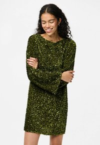 Zaļš sekvīnu garās piedurknes kleita ar brīvu piegriezumu, plašu dekoltē un teksturētu rotājumu, līdz ceļgaliem, ar maigu mirdzumu.