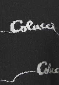 Svart genser med hvit strikket tekst som leser "Colucci" i kursiv skrift, med en myk tekstur og subtil glans.