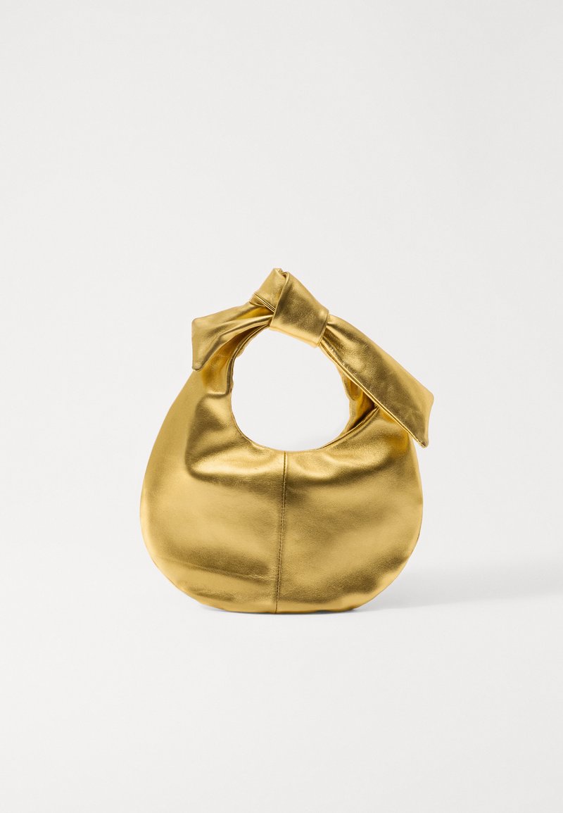 Sac à main en cuir doré avec un corps rond et une poignée nouée, présentant une texture lisse et un design sans coutures.