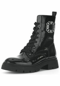 Stivaletto da combattimento in pelle verniciata nera con chiusura a lacci, suola nera spessa e dettaglio hardware decorativo sul lato. Finitura liscia e lucida.