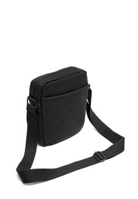 Čierna crossbody taška z hladkej kože, obdĺžnikový tvar, so zapínaním na zips, prednou vreckom a nastaviteľným látkovým popruhom.