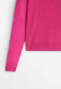 Pull en tricot fuchsia, avec une texture douce, des manches longues et des poignets côtelés, ainsi qu'une ourlet droit.