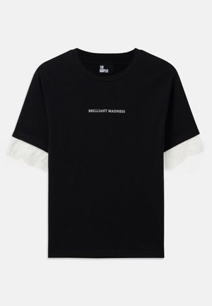 T-shirt en coton noir à manches courtes. Présente un texte blanc "BRILLIANT MADNESS" sur le devant et des accents à franges blanches sur les manches.