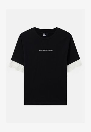 Black cotton t-shirt with short sleeves. Features white text "BRILLIANT MADNESS" on the front and white fringed accents on the sleeves.
