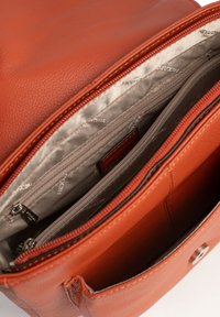 Borsa a mano in pelle marrone con texture liscia. Presenta diversi scomparti con cerniera e un interno foderato di grigio chiaro. Accenti in hardware argentato.