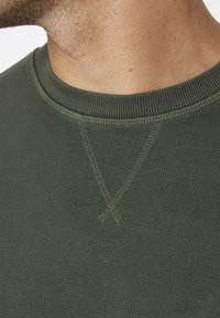 Dunkelgrüner strukturierter Sweatshirt mit einem gerippten Kragen, dreieckigen Steppnähten am Ausschnitt und einem glatten Finish.