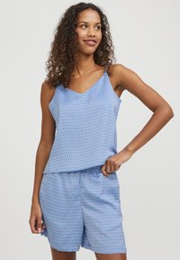 Blåmönstrad linne och shorts-set i lätt tyg; har tunna axelremmar och en avslappnad passform med vertikala linjemönster i kontrasterande färger.