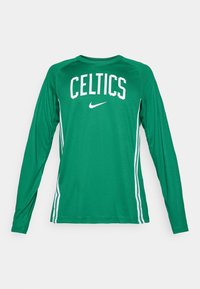 Grøn langærmet skjorte med "CELTICS" og Nike-logo i hvid. Har kontraststriber i hvid langs siderne. Fremstillet af letvægtsstof.