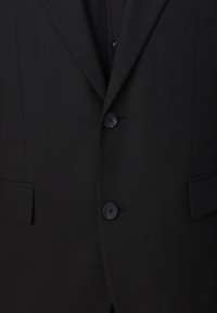 Black suit jacket featuring a notched lapel, two front pockets, and four black buttons. The fabric has a smooth texture with a subtle weave.