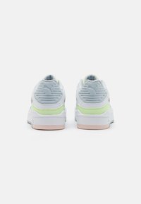 Baskets avec une tige blanche, des accents gris, et des détails verts clair et roses. Présente un matériau texturé au talon et des logos sur les côtés.