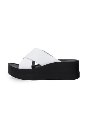 Black platform sandals with a sleek design, featuring a white crisscross strap made of a smooth material and a textured footbed.