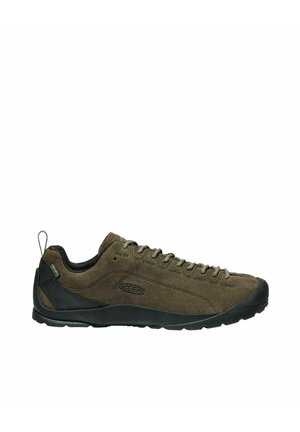 Scarpe da esterno in suede marrone con dettagli in gomma nera, lacci frontali, punta arrotondata e suola con grip testurizzato. Presenta un'etichetta di supporto sul retro.