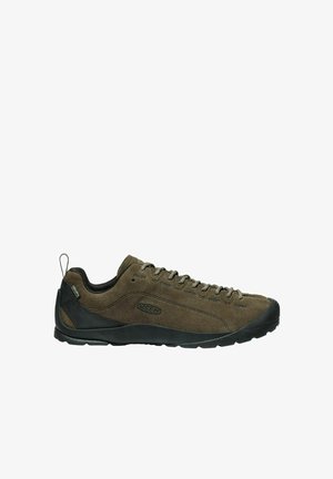 Scarpe da esterno in suede marrone con dettagli in gomma nera, lacci frontali, punta arrotondata e suola con grip testurizzato. Presenta un'etichetta di supporto sul retro.