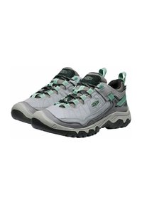 Light gray hiking shoes with black accents, green laces, and textured rubber soles. Features padded collar and heel pull tab.