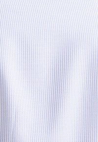 Lichtblauwe textuurstof met dunne, verticale witte strepen, met een gladde oppervlakte en een consistent patroon doorheen.