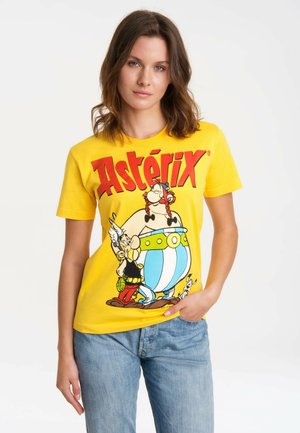 Gelbes Baumwoll-T-Shirt mit den Cartoon-Charakteren Asterix und Obelix, mit fettem roten "Asterix"-Text. Lässiger Schnitt, kurze Ärmel, schlichtes Design.