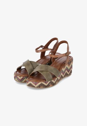 Sandali wedge in pelle verde oliva con design a strappo incrociato, soletta in legno e piattaforma intrecciata decorata con accenti beige, rosa e viola.