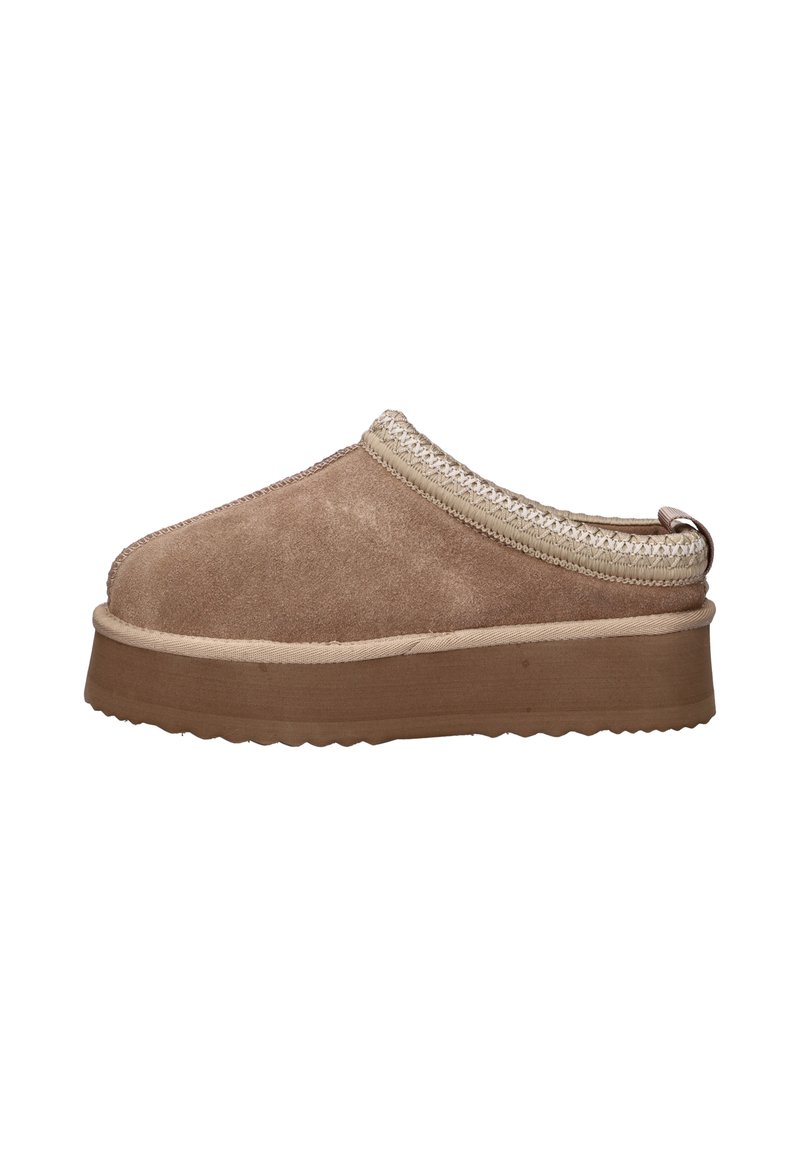 Mocassin en daim brun à enfiler avec une semelle épaisse et une bordure tressée autour de l'ouverture, sur un fond blanc.