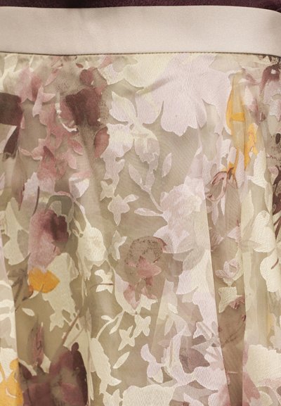 Διάφανο μπεζ ύφασμα με λουλουδάτο μοτίβο σε απαλούς ροζ, καφέ και κίτρινους τόνους, μαζεμένο κάτω από μια απλή κρεμ ζώνη μέσης.