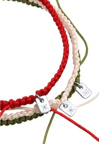 Flätade armband i röd, vit och grön med metalltaggar. Tillverkade av textilmaterial, med en strukturerad och sammanflätad design.