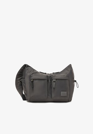 Große dunkelgraue Umhängetasche mit zwei vorderen Reißverschlusstaschen, verstellbarem Riemen und einem kleinen Markenzeichen auf der unteren rechten Tasche.